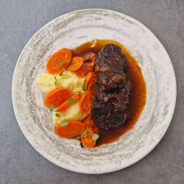 Geschmortes Rindfleisch in Rotwein, Kartoffelpüree und glasierte Karotten